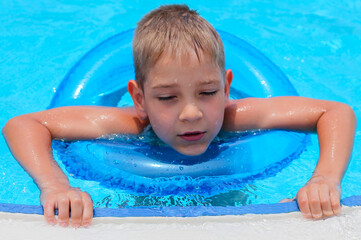 Fototapeta na wymiar Cute happy little boy swimming and snorking in the swimming pool