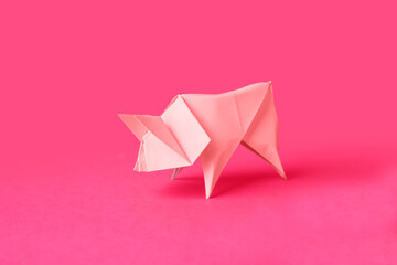 Origami art. Handmade bright paper pig on pink background