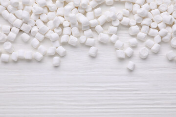 Fototapeta na wymiar Delicious marshmallows on white wooden table, flat lay