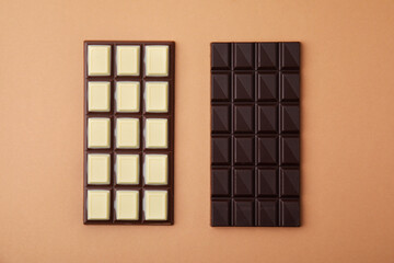 Tasty chocolate bars on brown background, flat lay