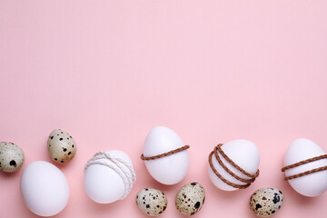 Beautifully decorated Easter eggs on pale pink background, flat lay. Space for text
