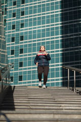 Fototapeta na wymiar confidence overweight woman running on stairs outdoor in city