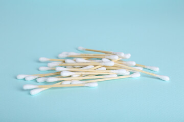 Wooden cotton buds on light blue background