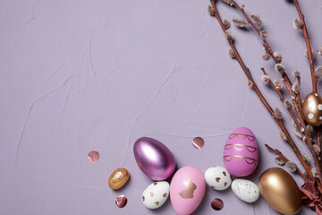 Flat lay composition with festively decorated Easter eggs and pussy willow branches on grey...