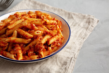 Homemade Penne With Tomato Sauce on a Plate, side view. Copy space.
