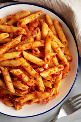 Homemade Penne With Tomato Sauce on a Plate, top view. From above, overhead, flat lay. Close-up.