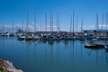Fototapeta na wymiar A small calm bay with a mooring for boats, yachts and catamarans against the backdrop of a sunny day, background