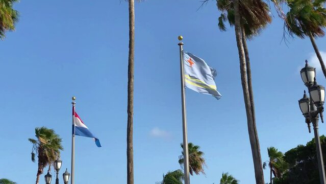 Flags of Aruba and the Netherlands flying in Oranjestad, Aruba. Country of Aruba is a constituent country of the Kingdom of the Netherlands physically located in the mid-south of the Caribbean Sea.