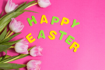 beautiful tulips flowers and word Happy Easter on pink background