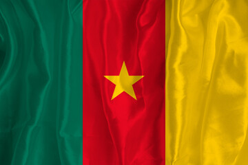 The flag of Cameroon on a silk background is a great national symbol. Fabric texture The official state symbol of the country.