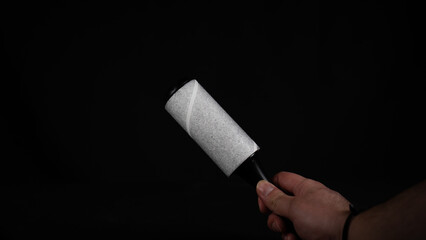 Roller for cleaning clothes from pet hair isolated on black background, close up