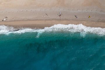 Drone view of deserted sandy beach and turquoise sea waves  - 577823500