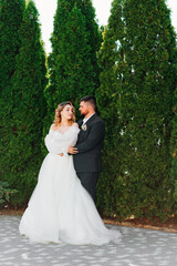 the bride and groom hugging and dancing in the park. 