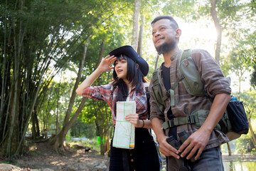 Family with father and daughter tourist backpack hiking doing activity while father looking binoculars in holiday together, man and teenager woman journey adventure trip and looking map.