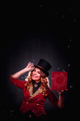Stage magician woman making soap bubbles show, an illusionist in theatrical clothes at black background. Lady actress in stage costume. Concept of theatrical performance and fun show. Copy text space