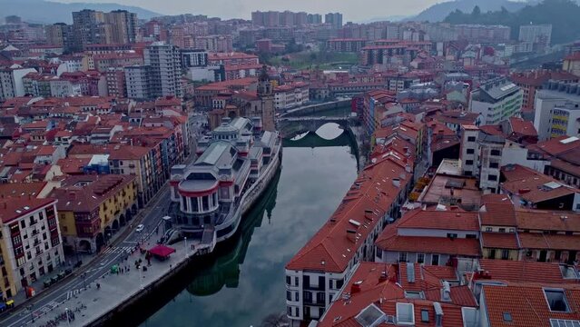 Flying drone in Bilbao, Spain over the food market Ribera next to the Nevión river 