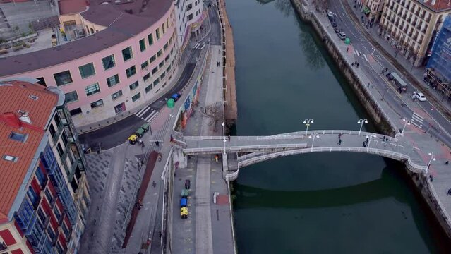Flying in Bilbao, Spain, flying forward while slowly tilting up and filming a tall crane 