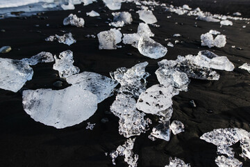 ice from a glacier on a background of magmatic black sand