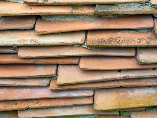 Background from the old tiled masonry. Orange tiles. Wall made of clay fragments