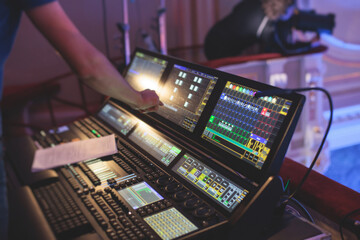 View of lighting technician operator working on mixing console workplace during live event concert...