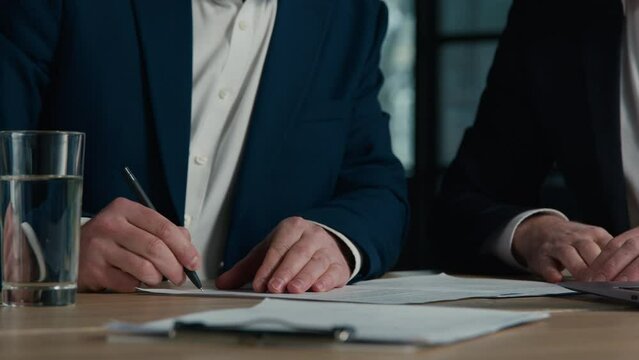 Close-up unrecognizable men businessmen business partners sign contract conclude successful transaction make handshake shake hands congratulations on signing document corporate partnership concept