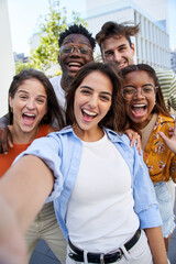 Vertical selfie young excited friends looking at camera happy. Smiling Group of people having fun together outdoors. Crazy community of college students. Modern lifestyle of multicultural people. - obrazy, fototapety, plakaty