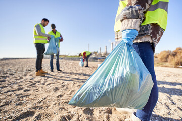 Group portrait of activists holding plastic waste. Teamwork standing up. Volunteers cleaning up...