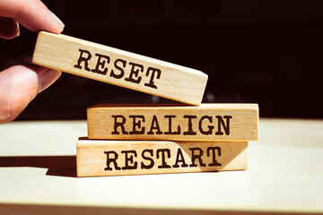 Wooden blocks with words 'Reset, realign, restart'.