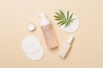 Face care products with eco pads on color background, top view
