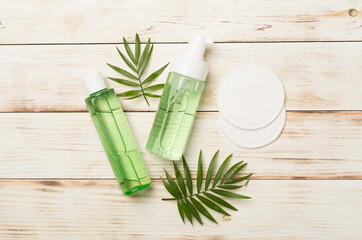 Face care products with eco pads on wooden background, top view