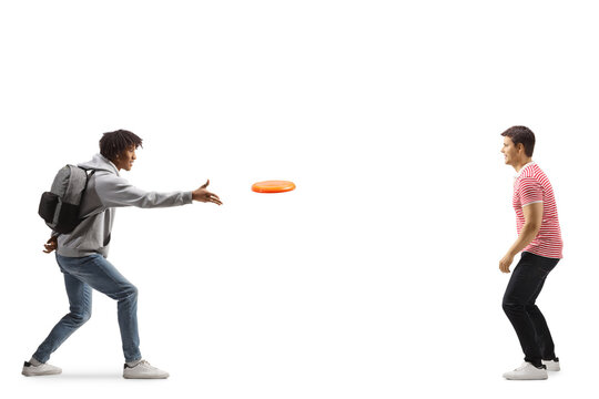 Full length profile shot of a young african american man throwing a flying disc with a young caucasian man
