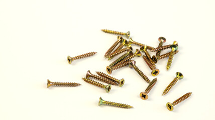 Scattered screws on a white background in a chaotic order. Steel screws for fastening. The concept of repair and installation.