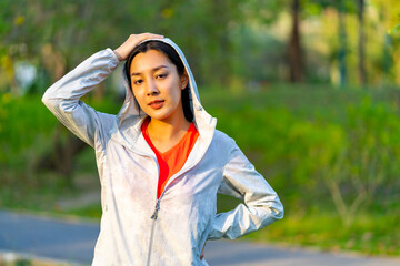 Portrait of Young Asian woman in sportswear jogging exercise at public park in summer morning. Healthy girl athlete enjoy outdoor activity lifestyle sport training fitness running workout in the city