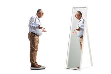 Full length shot of a mature man standing on a measuring scale in front of a mirror