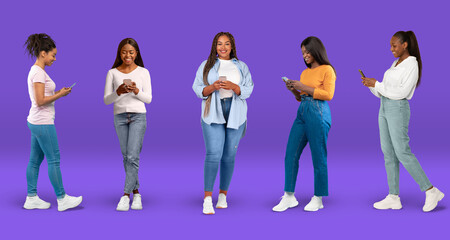 Obraz premium Cheerful young black women in casual typing on smartphone, watch video on blue background, studio