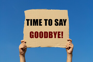Time to say goodbye text on box paper held by 2 hands with isolated blue sky background. This...