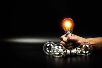 Close up hand choose light bulb or lamp with bright light for human resources or leadership and creativity thinking idea motivation or vision and knowledge learning and study or education concept.