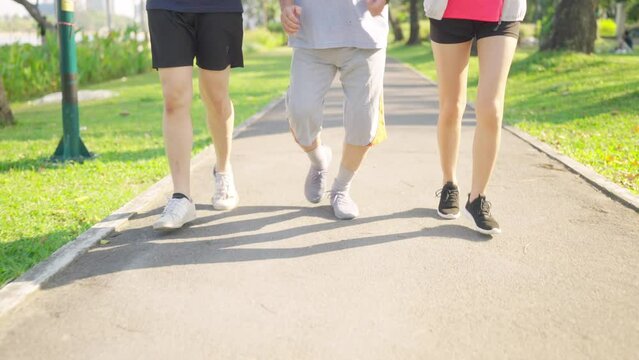 Asian couple with elderly father jogging exercise together at park. Retired old man with outdoor lifestyle sport training workout in the city. Family relationship and senior people health care concept