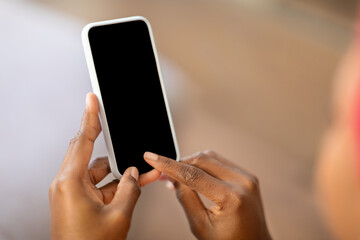 Cropped of black woman touching smartphone blank screen