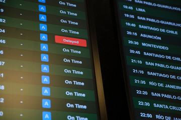 Screen with information on international flight departures, all are on schedule except one, marked...