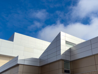Commercial external metal composite panels on a building with blue sky and clouds in the...