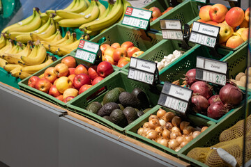 Avocado fruits in a supermarket. Hass variety produced in Peru and sold in Germany. Other vegetables and fruits are lying next to it. Groceries from organic quality.