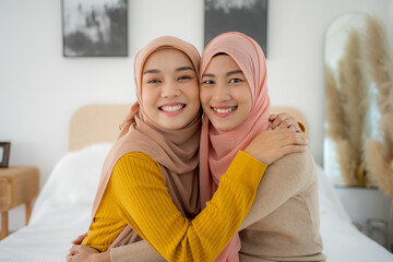Young Beauty Muslim woman talking and laughing on the bed. Happy two friends true friendship.