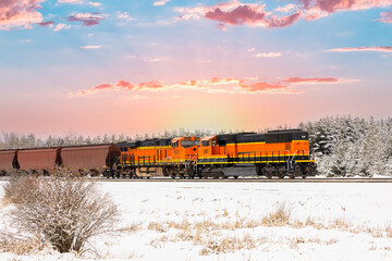 stunning scene of a freight train in winter with sunrise in background in northwest Montana