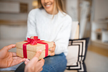 Millennial arab guy gives box with present to european woman, congratulates with Valentine day