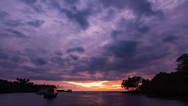 Timelapse - Beautiful sunset clouds over the ocean with sailboats in the distance at Big Island, Hawaii.