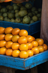 Fresh mandarin oranges or tangerines fruit with leaves in boxes at the open air local food market. Wholesale depot of exotic fruits. Local produce at the farmers market.