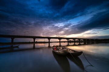 Obraz premium Beautiful sunrise at the lagoon with the boat the main focus. The concept of lonely feeling