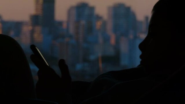 nene usando celular sentado en una silla