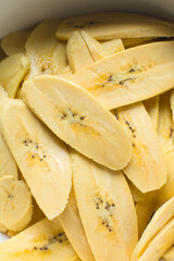 slices of ripe plantains in a white bowl, slices of yellow plantains for frying, process for making fried plantain